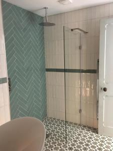 une salle de bain avec une douche avec une porte vitrée dans l'établissement Elegant Seaview Apartment, à Bangor