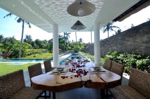 a wooden table in the middle of a patio at Villa Ashoka Canggu in Canggu