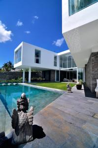 a house with a statue next to a swimming pool at Villa Ashoka Canggu in Canggu