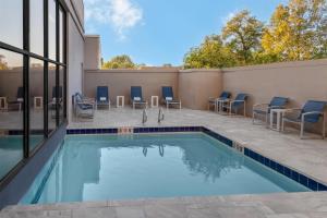 a pool with chairs and tables next to a building at DoubleTree by Hilton Springfield in Springfield