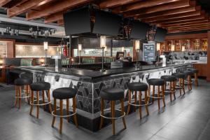 a bar in a restaurant with black stools at DoubleTree by Hilton Springfield in Springfield