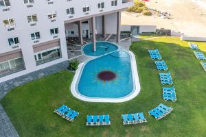 an overhead view of a pool with chairs and a building at Hilton Garden Inn Veracruz Boca del Rio in Veracruz