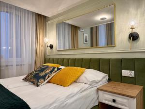 a room with a bed with a mirror and a table at Apartamenty Katarzynki by Rentoom in Toruń