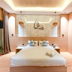 a bedroom with a large white bed with baskets on the wall at Firdaus Cafe& Hotel in Ban Bo So
