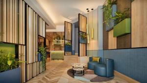 a lobby with blue furniture and plants on the walls at Hilton Garden Inn Rome Colosseum in Rome