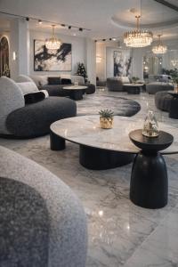 eine Lobby mit Sofas, einem Tisch und Stühlen in der Unterkunft Spa Hotel Ezeretz Blagoevgrad in Blagoewgrad