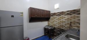 a kitchen with a sink and a refrigerator at Osama House Luxor in Al Qurnah