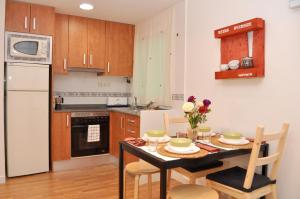 a kitchen with a table with two chairs and a kitchen with a stove at bcn4days Apartments in Hospitalet de Llobregat