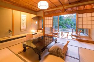 a living room with a glass table and chairs at 御宿竹林亭 in Takeo