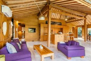 a living room with purple couches and a table at Villa Lucky in Canggu
