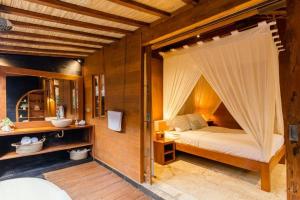 a bedroom with a bed with a mosquito net at Villa Lucky in Canggu