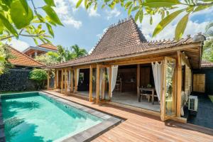 a villa with a swimming pool and a house at Villa Lucky in Canggu