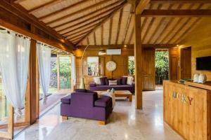 a living room with purple couches and a tv at Villa Lucky in Canggu