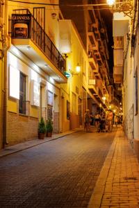 an empty street at night with people walking down the street at Irati in Benidorm