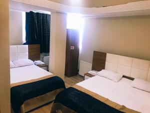 a hotel room with two beds and a window at Ceylan otel in Suşehri