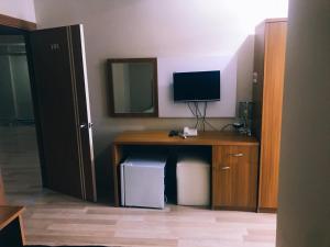 a room with a desk with a television and a mirror at Ceylan otel in Suşehri