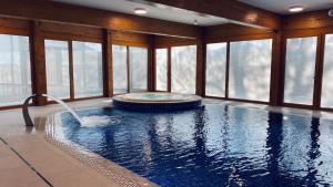 a swimming pool in a room with windows at my second home sumava in Železná Ruda
