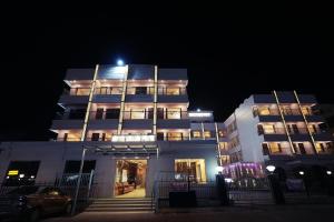 a large white building with stairs in front of it at night at Hotel SagarPriya in Digha