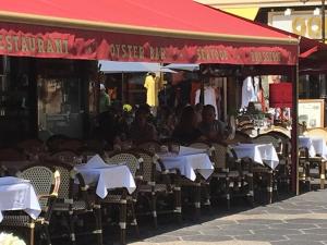 an outdoor restaurant with tables with white umbrellas at New central nice sea down town in Nice