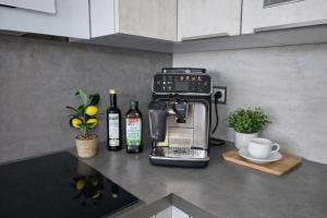 a kitchen counter with a coffee maker and bottles of wine at ErzZeit Urlaub mit Weitblick in Schwarzenberg/Erzgebirge