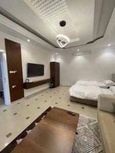 a bedroom with a bed and a flat screen tv at ADEL Privet Hostleإيواء خاص in Taif