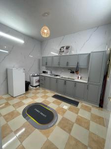 a large kitchen with a counter and a refrigerator at ADEL Privet Hostleإيواء خاص in Taif