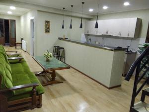 a living room with a table and a kitchen at Resort Hotel BIJNISI in Surami