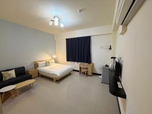 a hotel room with a bed and a couch at 回家浪 in Hengchun South Gate