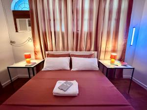 a bedroom with a bed with two tables and a window at Haraya Beach House in Roxas City