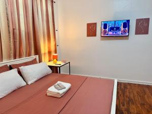 a bedroom with a bed with a tv on the wall at Haraya Beach House in Roxas City