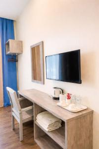 a desk in a hotel room with a flat screen tv at KARANG TIMUR Hotel in Kuantan