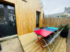 a red table and chairs on a wooden deck at Atelier Cancalais - Hypercentre, maison de ville in Cancale