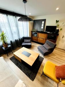 a living room with a coffee table and chairs at Atelier Cancalais - Hypercentre, maison de ville in Cancale