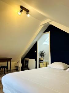 a bedroom with a white bed and a window at Atelier Cancalais - Hypercentre, maison de ville in Cancale