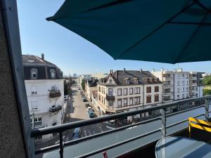 a view of a city from a balcony with an umbrella at 50m2 côté Bâle parking inclus in Saint-Louis