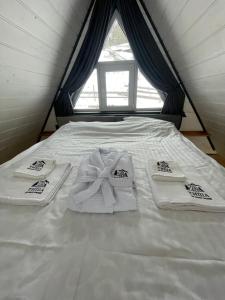 a bed with towels on it with a window at Тиша in Verkhovyna