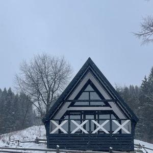 a building with a gambrel roof in the snow at Тиша in Verkhovyna +2 photos