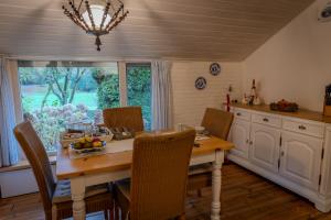 a dining room with a table and chairs and a window at Vledderstee in Vledderveen