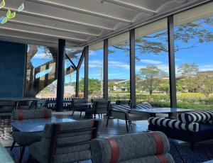 a lobby with couches and tables and windows at Ibis Styles Subic in Olongapo