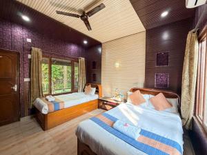 a bedroom with two beds and a window at Chitwan Forest Resort with swimming pool , Chitwan National Park in Sauraha +26 photos