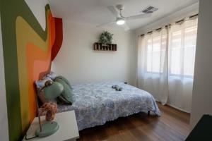 a bedroom with a bed and a lamp on a table at Spearwood Little Getaway in Spearwood