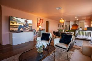 a living room with a large tv on the wall at Spearwood Little Getaway in Spearwood