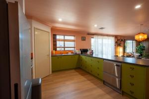 a kitchen with green cabinets and a counter top at Spearwood Little Getaway in Spearwood +24 photos