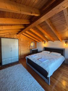 a bedroom with a large bed and a wooden ceiling at Gem Guest House in Lazarat