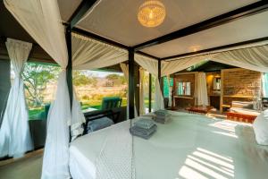 a large bed in a room with a window at Sian-simba-river-lodge in Victoria Falls +41 photos