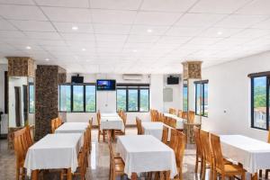 a dining room with white tables and chairs and windows at Friend Hotel Hà Giang in Ha Giang +95 photos