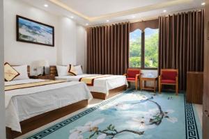 a hotel room with two beds and a large window at Friend Hotel Hà Giang in Ha Giang