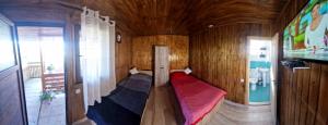 a small room with a red couch in a wooden room at Casa Roko in Sfântu Gheorghe