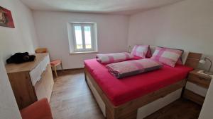 a bedroom with a bed with a red blanket at Ferienwohnung Tulipana in Müstair