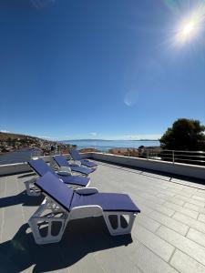 a row of chaise lounges on a beach at Apartments Ars Vivendi in Trogir